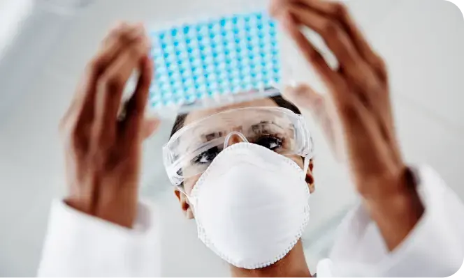 Scientist looking at and holding lab samples Scientist looking at and holding lab samples