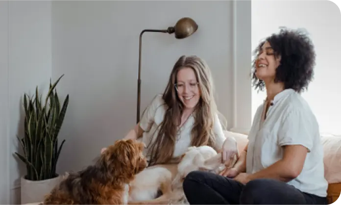 Women smiling and petting a dog