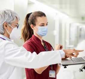 Two healthcare providers looking at a computer screen Two healthcare providers looking at a computer screen